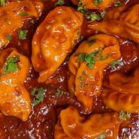 Spicy Vindaloo Chicken Momos · Chicken stuffed dumplings tossed in house made masala and spicy vindaloo sauce, served with ...
