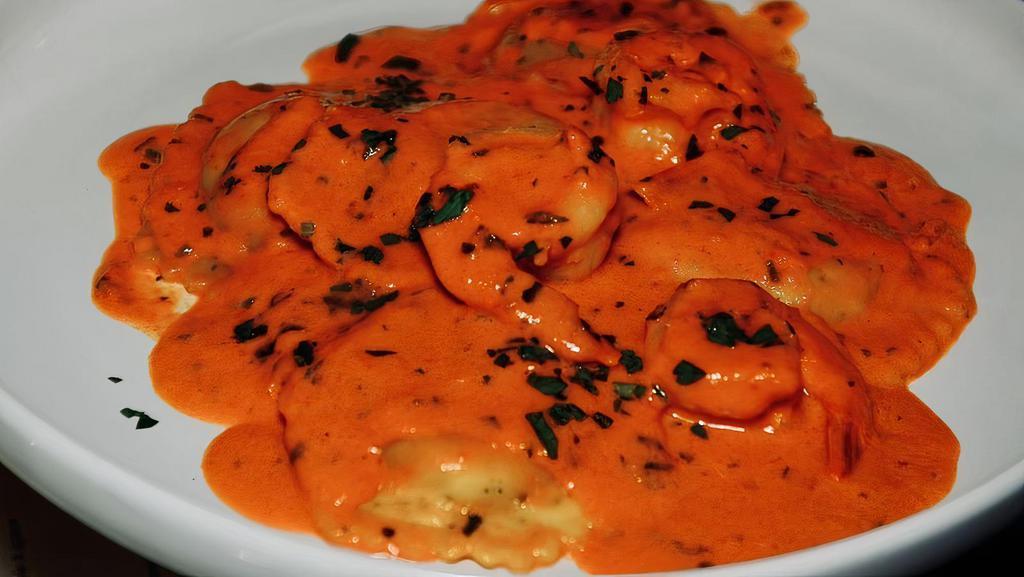 Ravioli Di Aragosta · Maine lobster ravioli topped with tiger prawns in pink sauce.