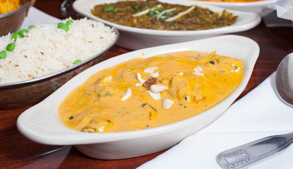 Chicken Korma · Chicken thigh cooked in a rich, creamy tomato and onion paste garnish with cashew and raisins.