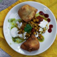 Samosa Chaat · Classic deep fried pastry stuffed with potatoes served on fresh bed of garbanzo beans.