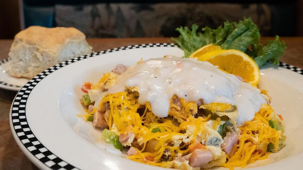 The Scrambowl · A hearty all-in-one bowl of ham, bacon, link sausage, eggs, bell pepper, onion & pickled jalapeño, scrambled over country red potatoes, then topped with cheddar cheese & country gravy. Served with a housemade biscuit.