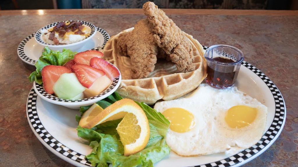 Chicken & Waffle & Eggs · Our secret recipe sweet cream waffle, topped with tender boneless chicken breast, hand-breaded in seasoned flour and deep-fried golden brown.  Served with syrup, cheesy bacon grits, 2 eggs any style and fresh fruit.