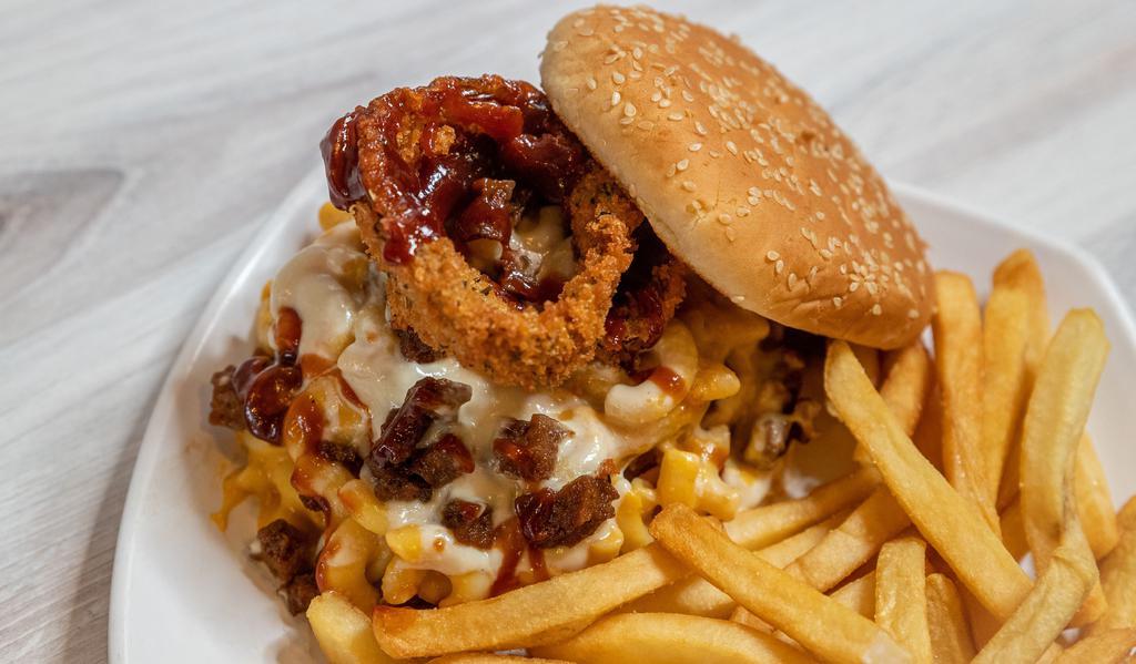 Backyard BBQ Burger · Vegan patty topped with mac and cheese, shredded mozzarella, bacon, fried onion rings, and BBQ sauce on a sesame bun.
