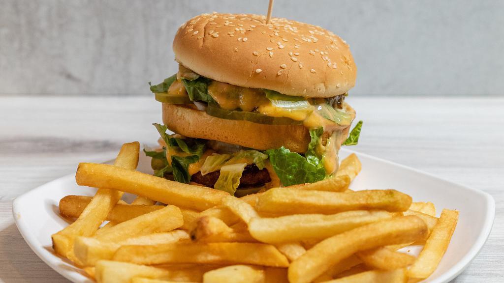 Double Decker Burger · Two vegan patties with thousand island, pickles, lettuce, and cheese sauce on a sesame bun.