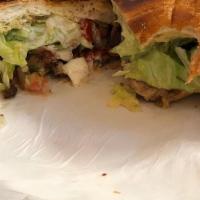 Torta · Sour cream, guacamole, cheese, lettuce, tomato and your choice of meat on a Mexican bread ro...