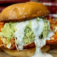 Buffalo Chicken Burger · Pickle-brined crispy chicken breast tossed in buffalo sauce, ranch and poblano slaw on a bri...