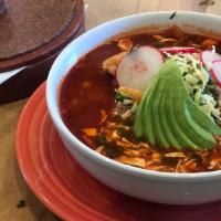 Rojo Pozole · Tender pieces of chicken slowly simmered in chili guajillo broth with hominy served with cho...