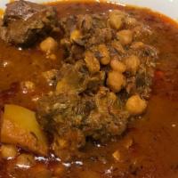 Abgoosht (Lamb Shank Stew) · Tender pieces of lamb simmered in tomato and savory broth with potato, tomato, onion, garban...