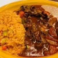 Bistec Ranchero · Full plate of strips of steak cooked in a special red sauce and fresh vegetables, served wit...
