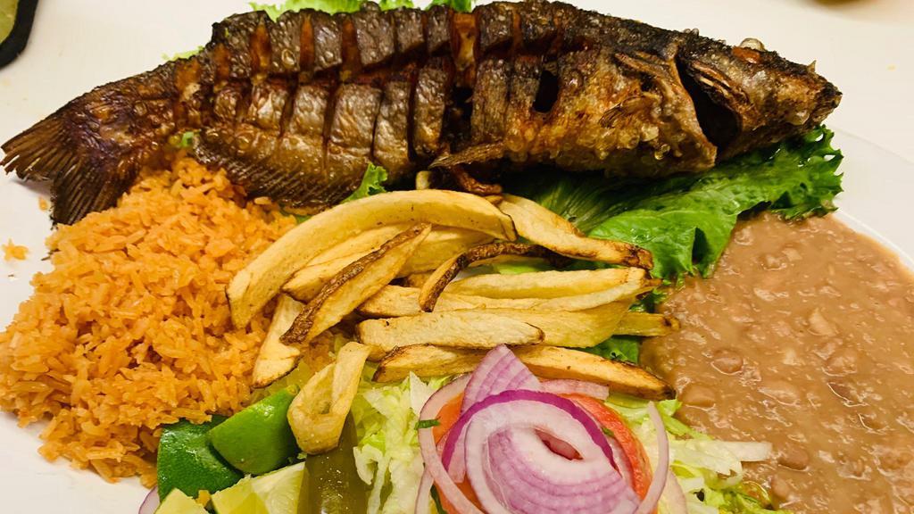 Pescado Frito · Whole cut fish, deep fried served with beans, salad, French fries, and guacamole.