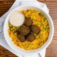 Green Herb Falafel Rice Bowl · Turmeric spiced Basmati rice simmered with tomatoes, garlic, onions, mint, and parsley. Topp...