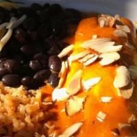 Enchiladas Guajillo · Two corn tortillas filled with meat or cheese and topped with Guajillo sauce and sliced almo...