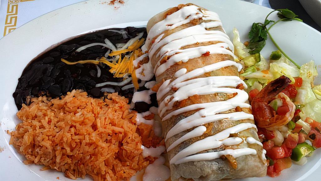 Vallarta Burrito · Prawns sautéed garlic butter, choice of beans, rice, and avocado, topped with cheese and sour cream and crowned with garlic butter sauce.