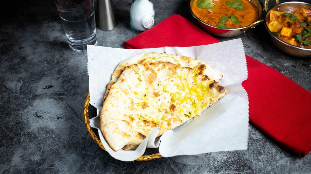 Garlic Naan · Freshly baked bread in a clay oven garnished with garlic and butter. Talk about getting' fresh.