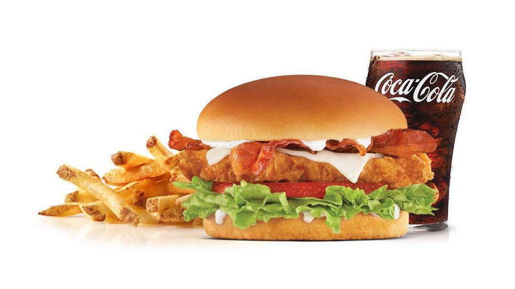 Hand-Breaded Bacon Swiss Chicken Sandwich Combo · Premium, all-white chicken fillet, hand dipped in buttermilk, lightly breaded and fried to a golden brown, topped with bacon, Swiss cheese, lettuce, tomato, and mayonnaise on a potato bun. Served with Fries and a Soft Drink.