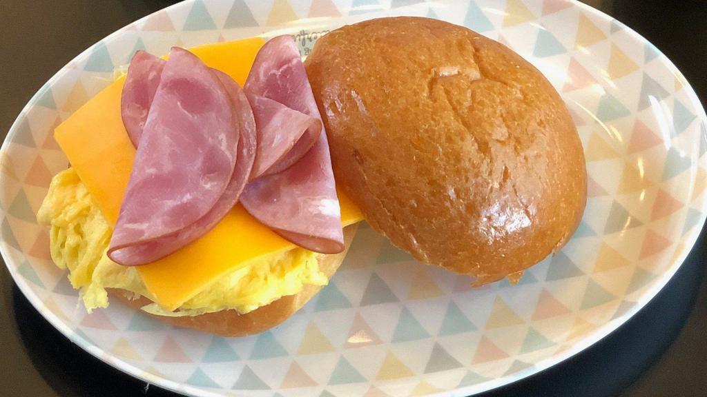 Egg , Ham ＆ Cheddar Breakfast Sandwich · Two eggs scrambled, ham, melty Cheddar cheese on a brioche bun.