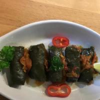 Dolmeh · Cooked grape leaves stuffed with rice and green herbs.