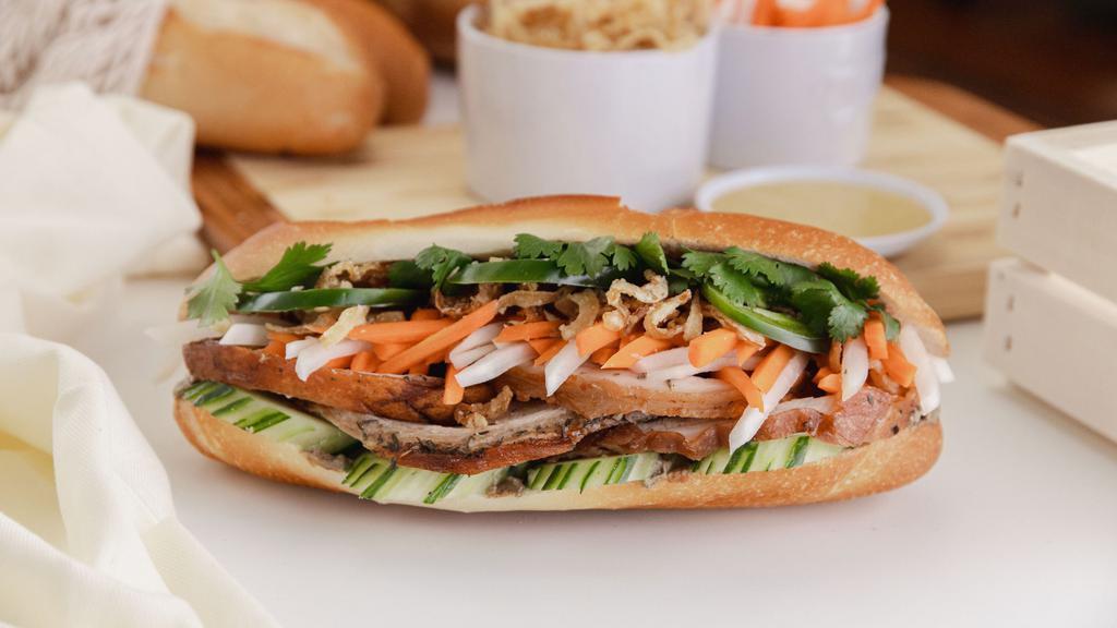 Porchetta Bánh Mì · Slow roasted pork belly, crispy fried onions, sweet pickled carrots & daikons, cucumbers, cilantro, Mommy's Signature Sauce, chicken pate, jalapeños in a fresh baguette