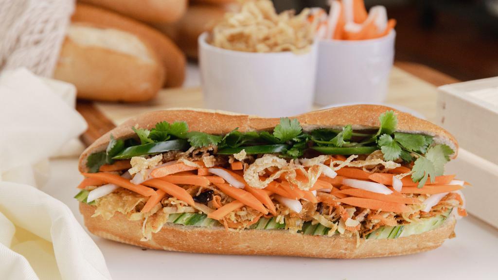 Veggie Banh Mi · Baguette Bánh Mì Bì Chay: Mixed shredded tofu/yams/ taro/ mushrooms/ carrots &j icama with crispy fried onions, cucumbers,  sweet pickled carrots & Daikons, cilantro, Mommy's signature cilantro aioli, jalapenõs in a fresh baguette