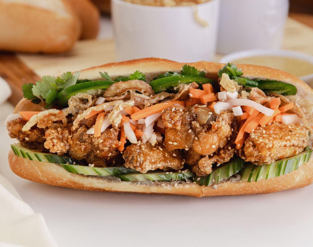 Fried Chicken Banh Mi · Baguette Bánh Mi: Fried chicken glazed with our signature sweet and savory fish sauce, crispy fried onions, sweet pickled carrots & daikons, cucumbers, cilantro, Mommy's Signature Sauce, chicken pate, jalapeños in a fresh baguette