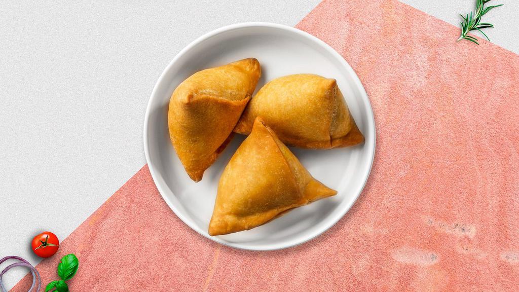 Vegetable Samosa · Two crispy puffs stuffed with potatoes and green peas fried in a crispy wheat layer.