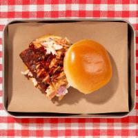 Pulled Chicken Sandwich · Smoked pulled chicken with coleslaw and  bbq sauce on a bun.