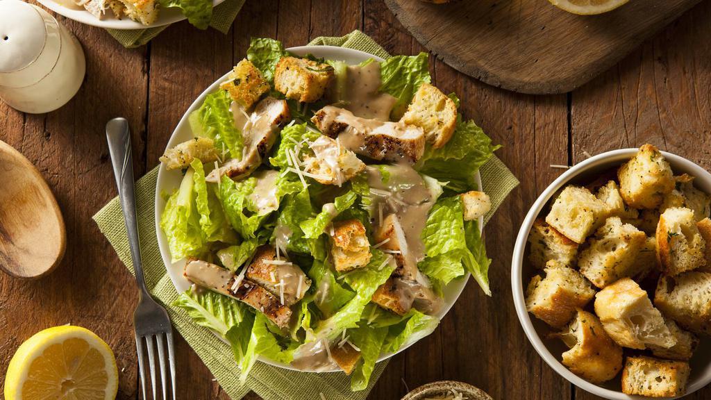 Caesar Salad · Crisp romaine lettuce topped with fresh Parmesan cheese and herb croutons served with a side of caesar dressing and bread of choice.