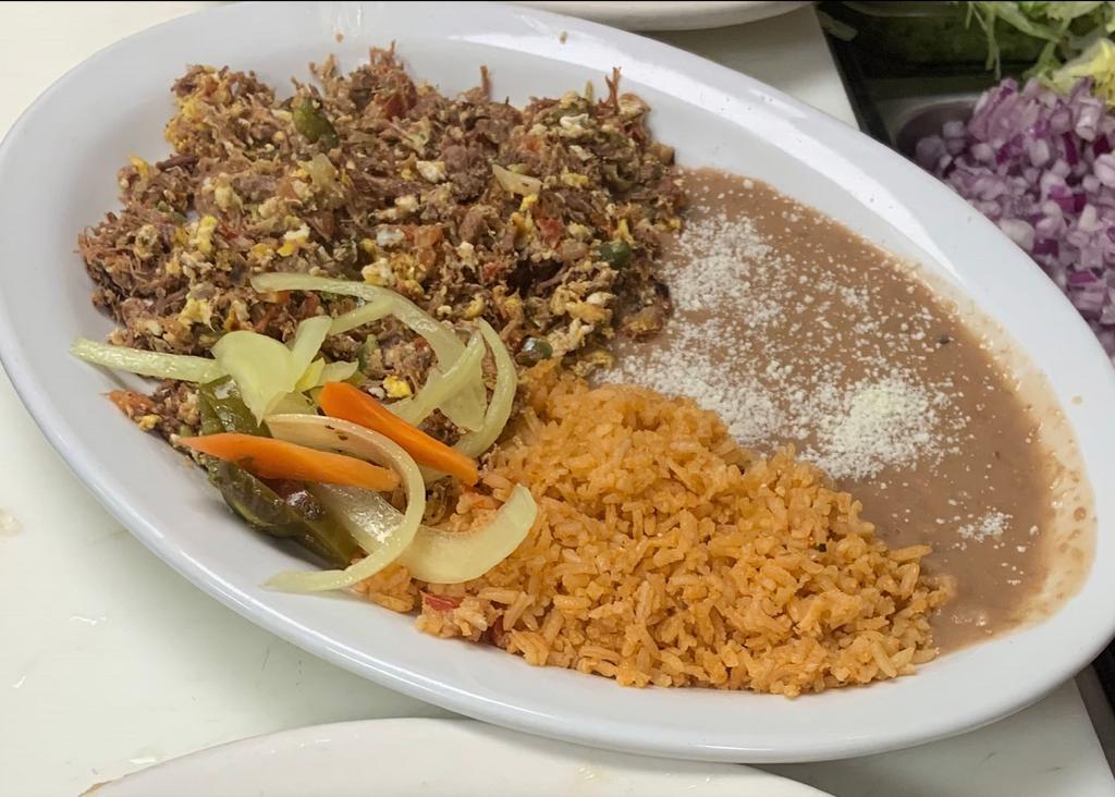 Machaca con Huevos · Shredded beef with scrambeled eggs. Comes with tortillas, rice, and beans.