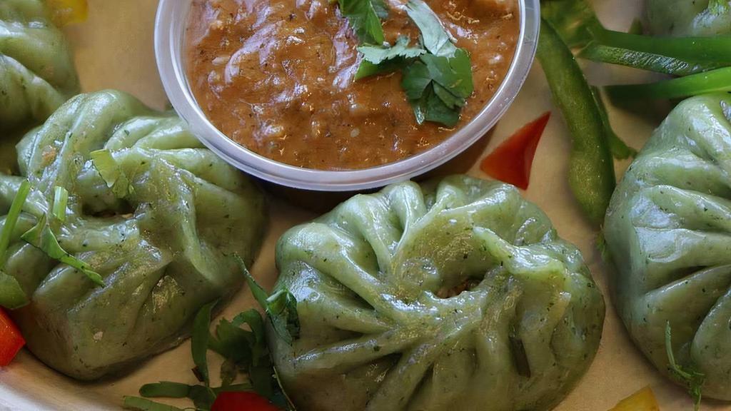 Veggie Momo  · Vegetarian. Famous Nepalese style steamed veggie dumpling served with tomato & sesame chutney.