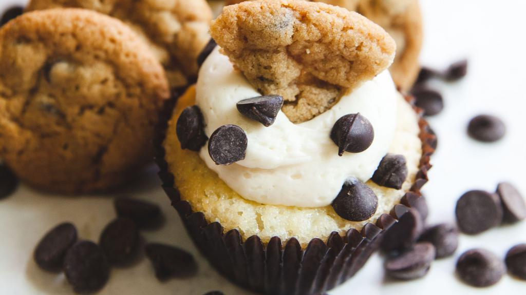 Chocolate Chip Cookie Dough (FLAVOR OF THE MONTH) · Vanilla cake with chocolate chip cookie baked in. Vanilla butter cream with mini chocolate chips on the sides and a quarter cookie garnish.