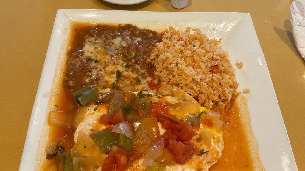 Huevos Rancheros · 2 over easy eggs, on top of a fried corn tortilla, topped with cheese and our special ranchero sauce. Served with rice, beans, and tortillas.