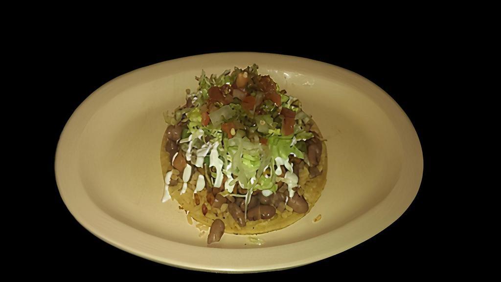 SUPER TACO · Big corn tortilla topped with meat, rice, whole beans, lettuce, sour cream, cheese, and salsa.