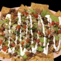 NACHOS · Vegetarian. Tortilla chips topped with melted cheese, meat, refried beans, sour cream, guaca...