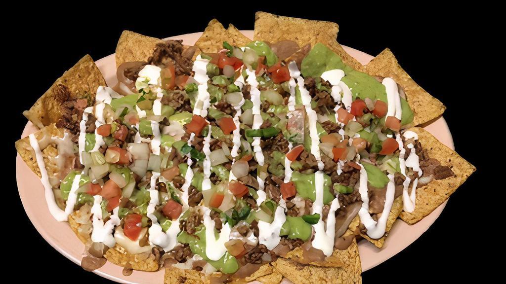 NACHOS · Vegetarian. Tortilla chips topped with melted cheese, meat, refried beans, sour cream, guacamole, and salsa.