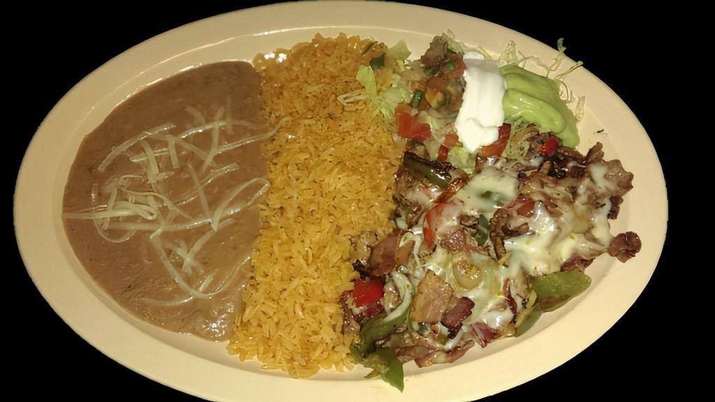 ALAMBRE PLATE · Beef strips grilled with bacon, bell peppers and topped with melted cheese.  Served with rice, refried beans topped with cheese, lettuce, sour cream, guacamole, salsa and corn tortillas.