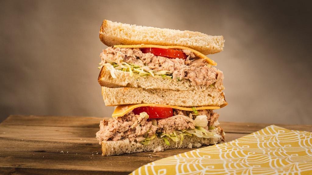 The Tuna · tuna salad topped with sliced onions, swiss cheese, shredded lettuce and tomatoes.
