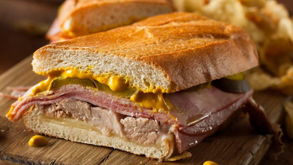 Hot Grilled Cuban Sandwich · Ham, pork loin, swiss cheese, yellow mustard, dill pickles on a baguette.