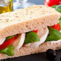 Hot Tomato and Mozzarella Sandwich with Basil · Fresh tomatoes, creamy fresh mozzarella cheese, basil, balsamic vinegar and olive oil on a c...