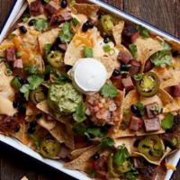 SMOKED BBQ NACHOS · Lucille's Favorite!. Crisp tortilla chips layered with melted cheese, black beans, smoked ja...