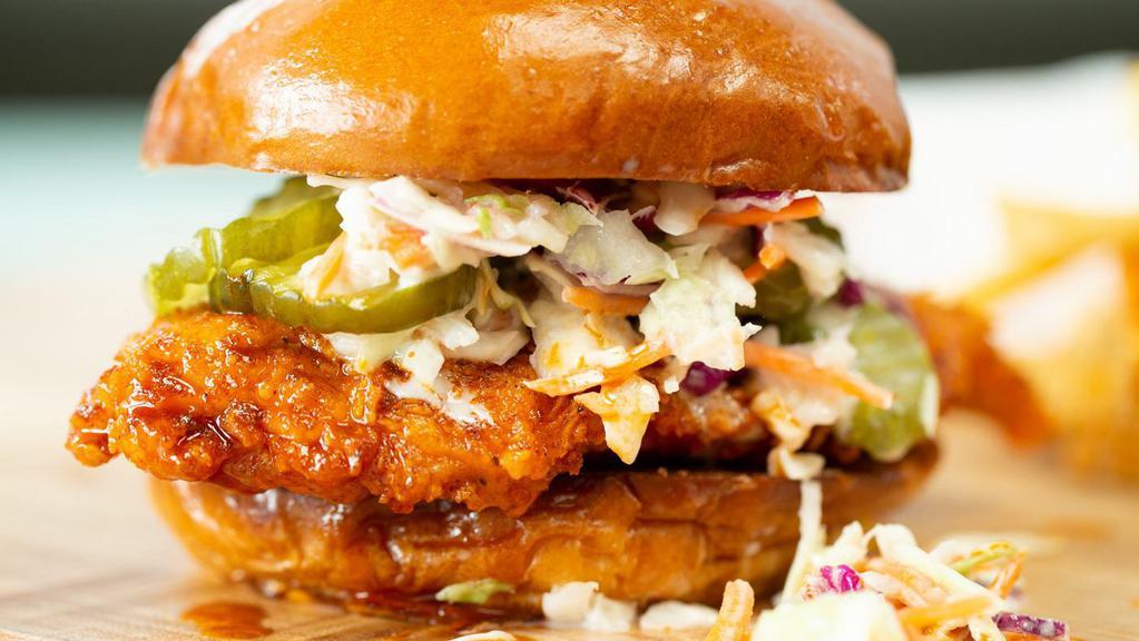 NASHVILLE HOT CHICKEN SANDWICH · Extra spicy, Nashville style, crispy fried chicken breast topped with sweet pickles and creamy coleslaw on a soft brioche bun. Served with Lucille's own Alabama White BBQ Sauce for dipping.