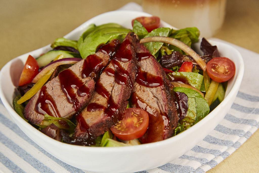 TRI TIP SALAD · Slow-smoked tri tip, hand-carved to order and served on a bed of mixed field greens, tomatoes, sweet red onions, cucumbers, red and yellow peppers and avocado, served with our tomato vinaigrette dressing on the side.