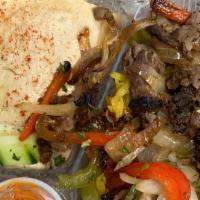 Lamb Shawarma Platter · Juicy lamb with rice, hummus, grilled onions and bell peppers, pickles, and a side of pita.
