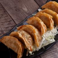 Gyoza (7 pcs) · Deep fried pork potstickers with a side of a soy vinegar and chili oil sauce.