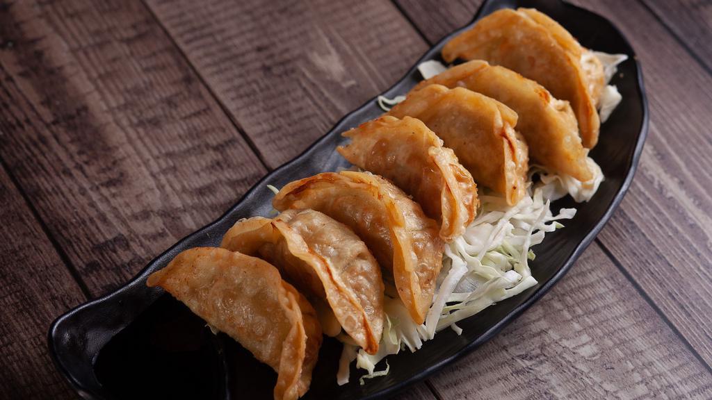 Gyoza (7 pcs) · Deep fried pork potstickers with a side of a soy vinegar and chili oil sauce.