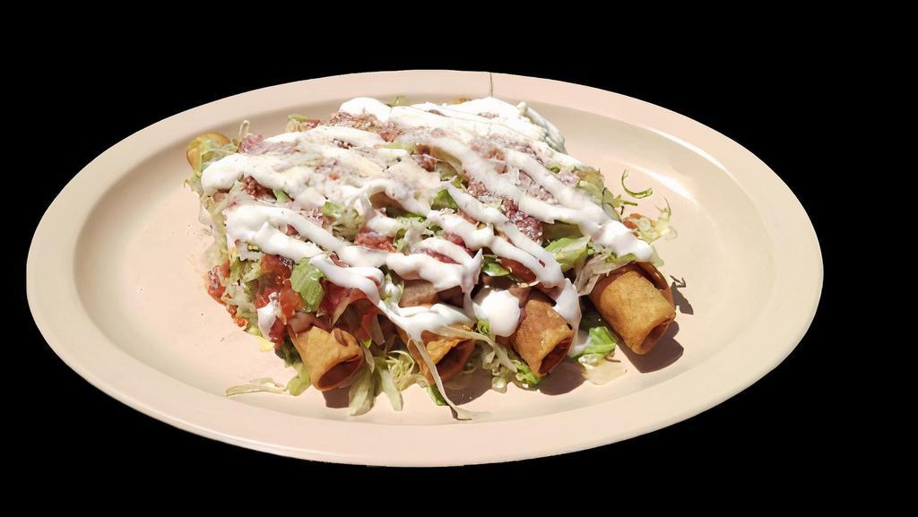 FLAUTAS VEGGIE · Four crispy rolled taquitos filled with Potatoes, topped with whole beans, lettuce, sour cream, salsa and cheese.