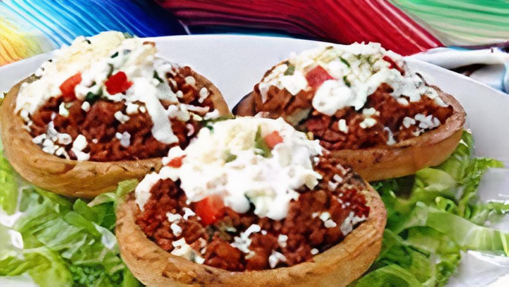 SOPES (2pcs) · Two thick corn masa tortillas topped with meat, refried beans, lettuce, sour cream, cheese and salsa.