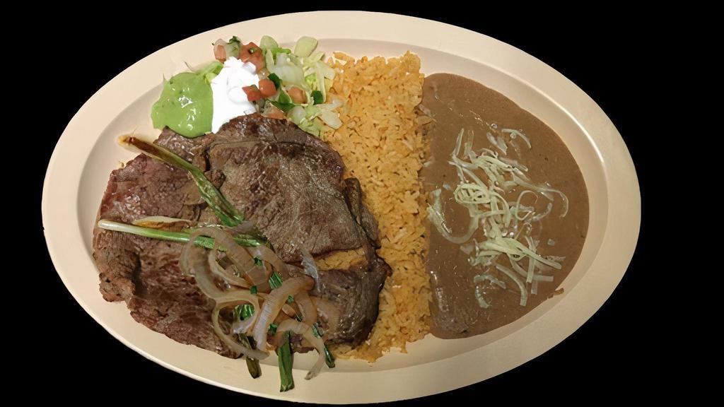 CARNE ASADA PLATE · Grilled beef steaks served with rice, refried beans topped with cheese, sour cream, guacamole, salsa and tortillas.