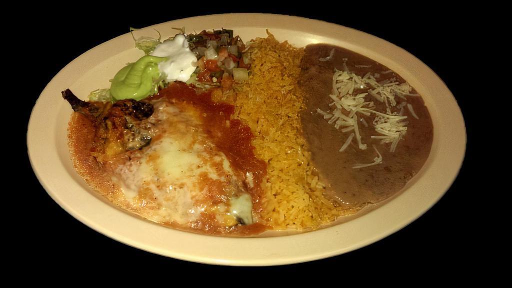 CHILE RELLENO · Roasted pepper stuffed with cheese, covered in egg batter, and mild tomato sauce, served with rice, refried beans topped with cheese, sour cream, guacamole, salsa and tortillas.