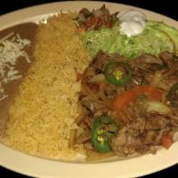 STEAK RANCHERO · Beef strips grilled with green peppers, onions and tomatoes,  served with rice, refried bean...