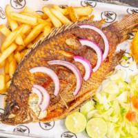 FRIED TILAPIA (Mojarra) · Tilapia whole fish topped with sautéed vegetables.